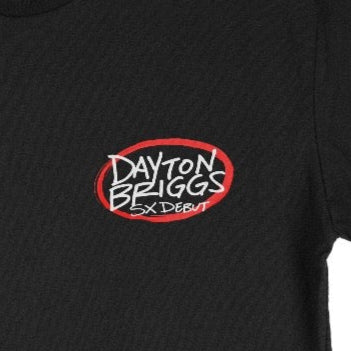 Close up of the chest print on the Dayton Briggs SX Debut 2025 Tshirt. White font with red oval.