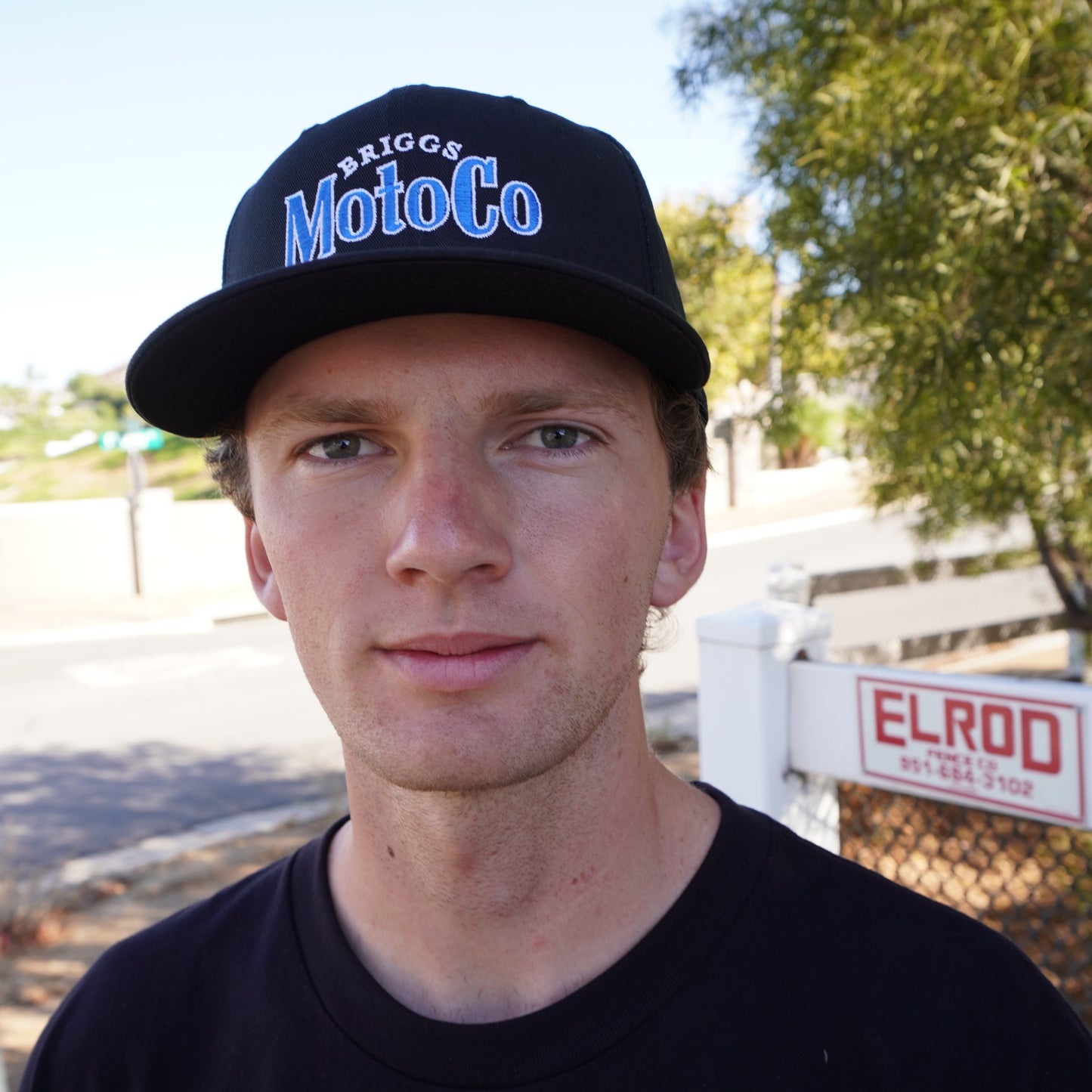 Dayton wearing a black baseball hat with Briggs MotoCo embroidered in Blue and White.