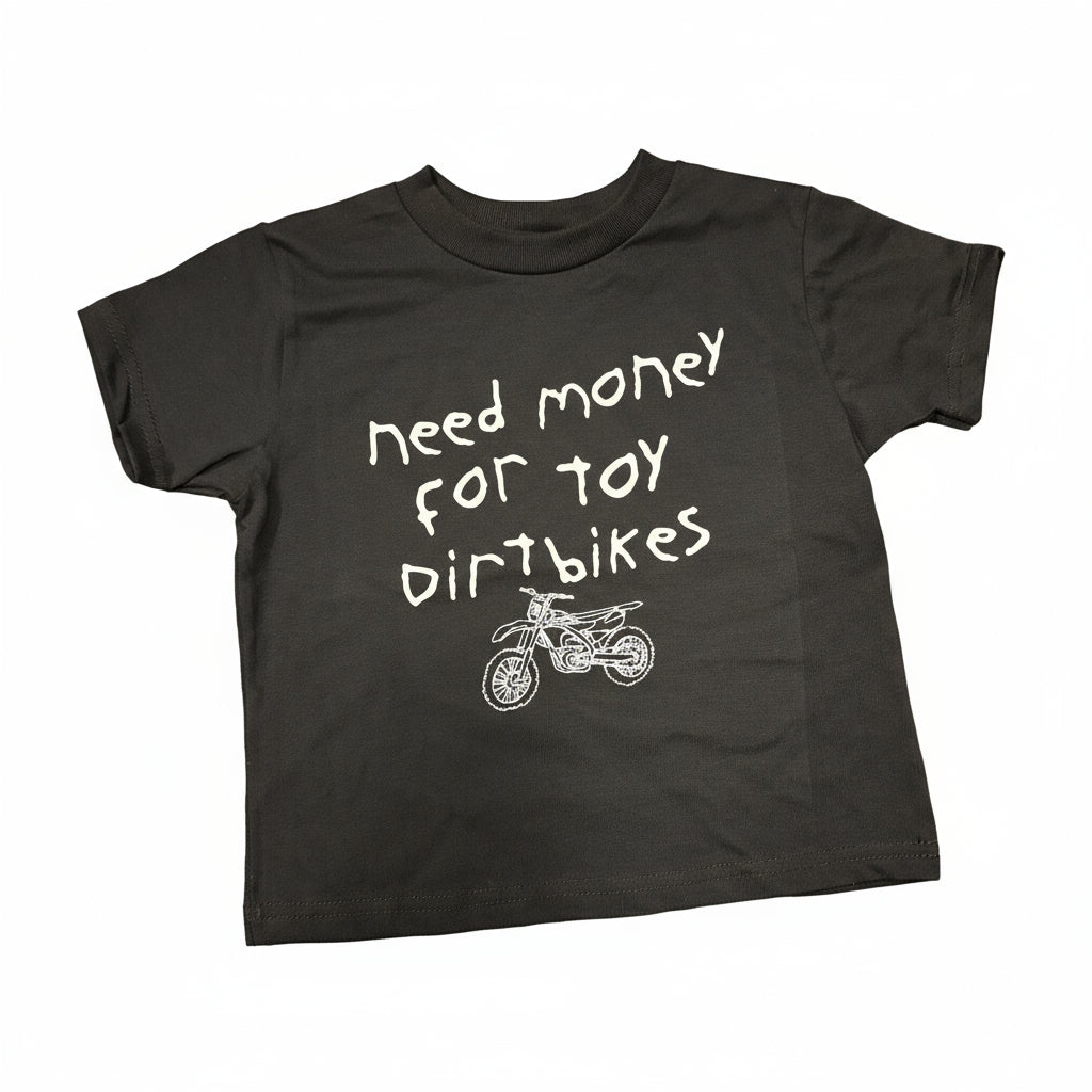 Black Toddler Tshirt with white handwritten font that says "Need Money for Toy Dirtbikes" with a sketchy dirtbike drawing